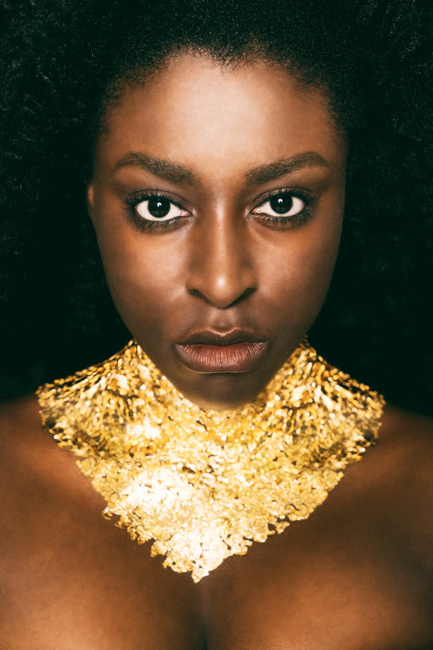 portrait photography of girl with gold plates on neck