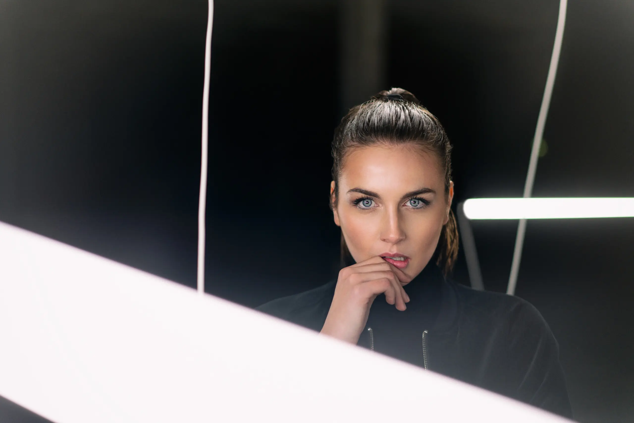 fashion photography of a model in industrial warehouse with neon tubes