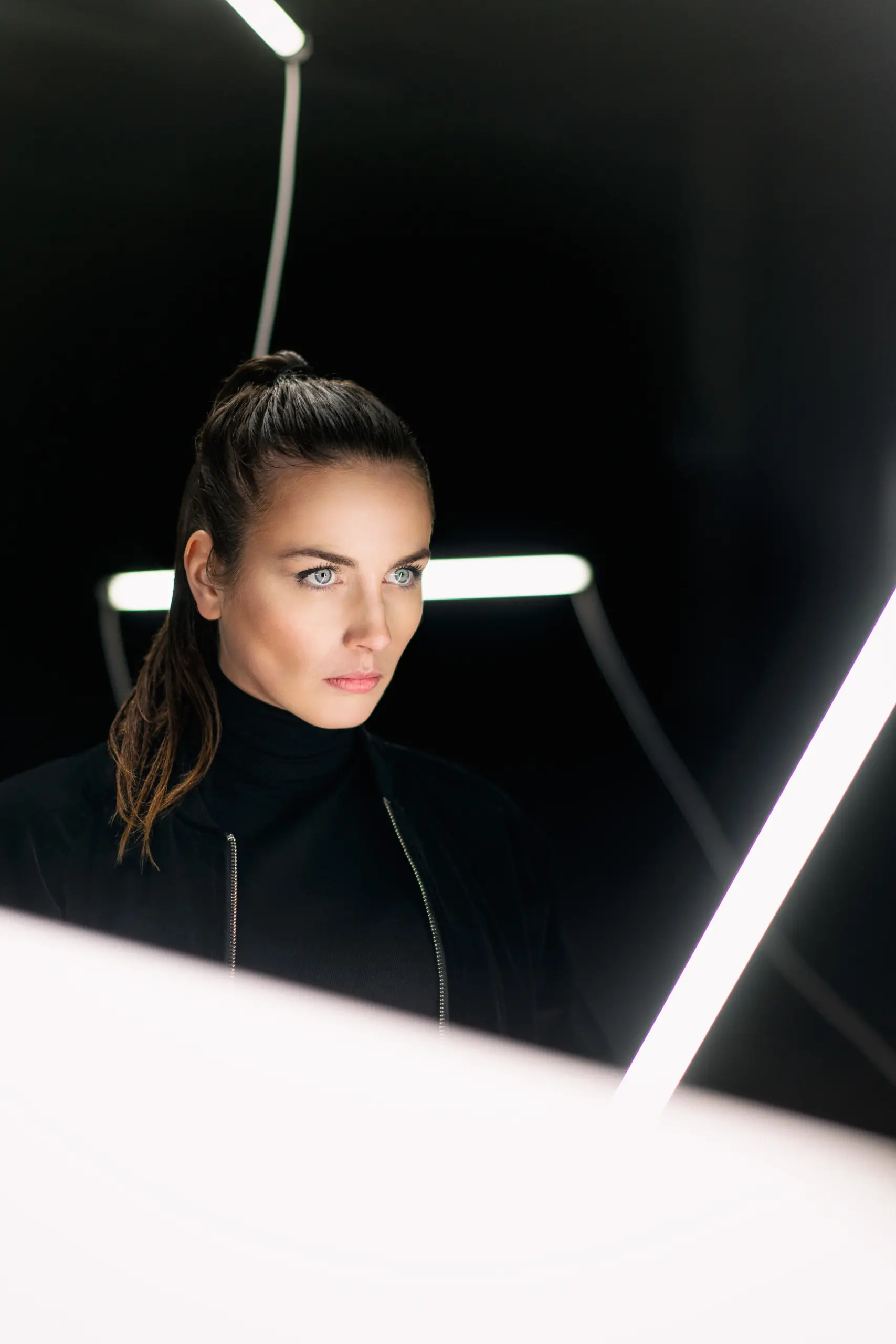 fashion photography of a model in industrial warehouse with neon tubes