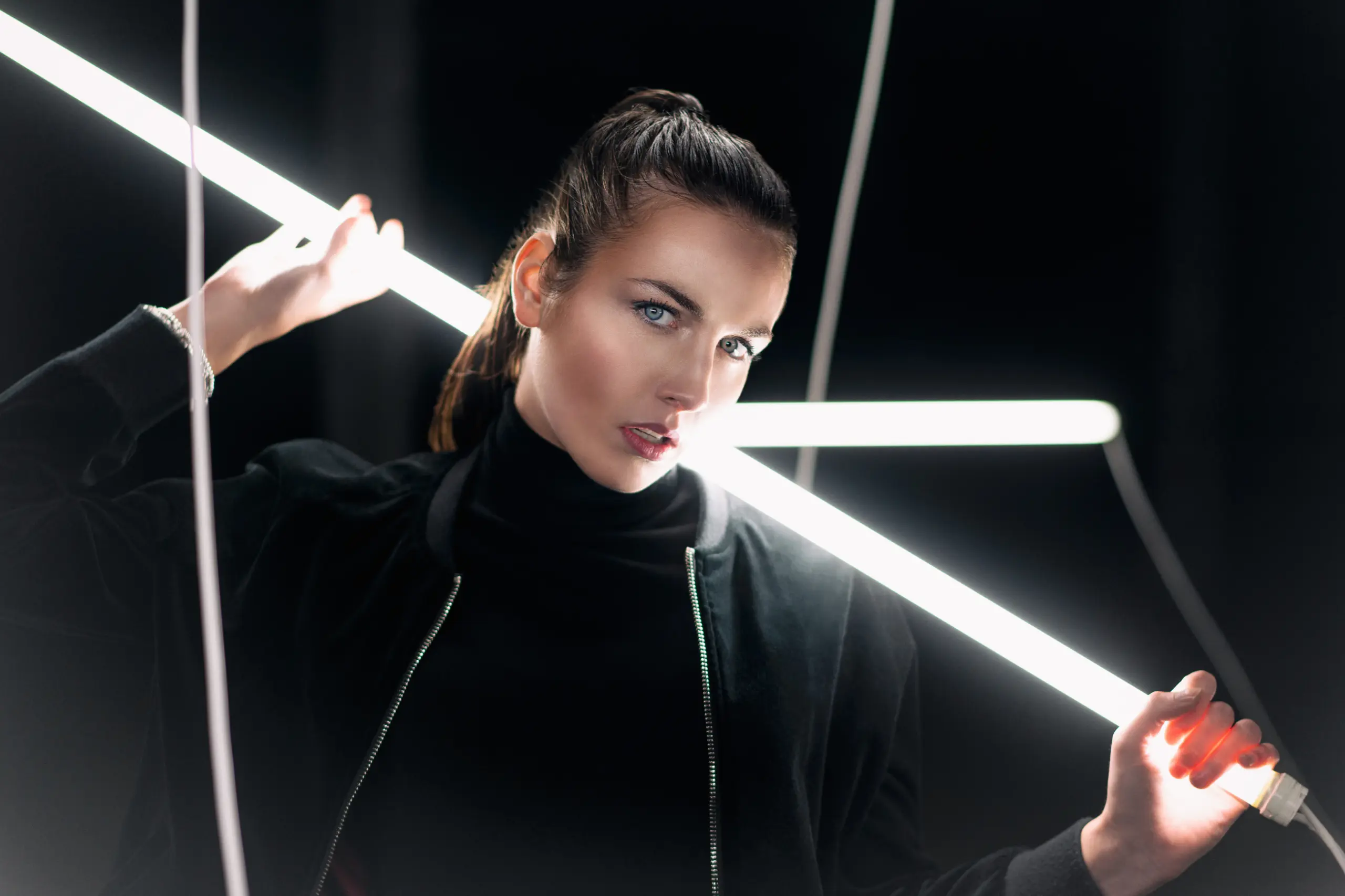 fashion photography of a model in industrial warehouse with neon tubes